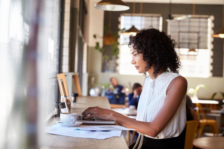 A woman working at a computer in an office setting.