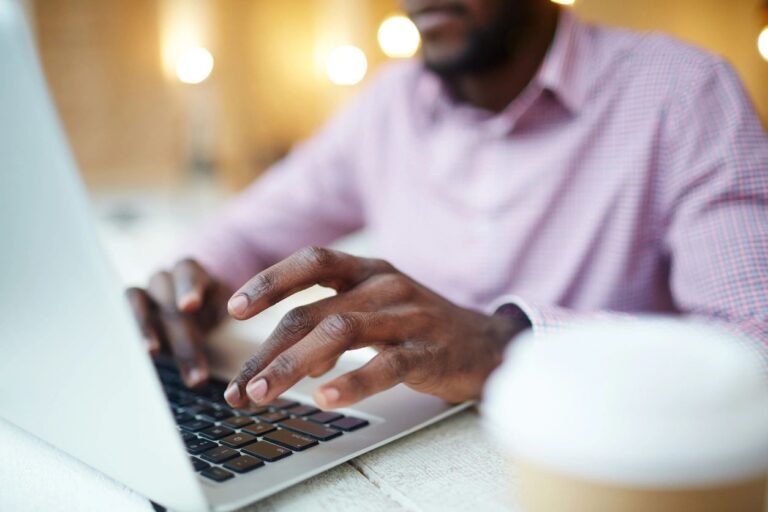 Man in an office setting working on computer.